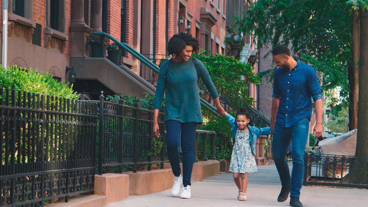 A happy Black family exploring a vibrant city street together