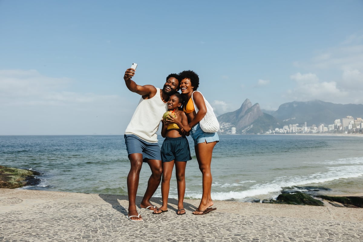 A happy Black family taking a joyful selfie on the beach