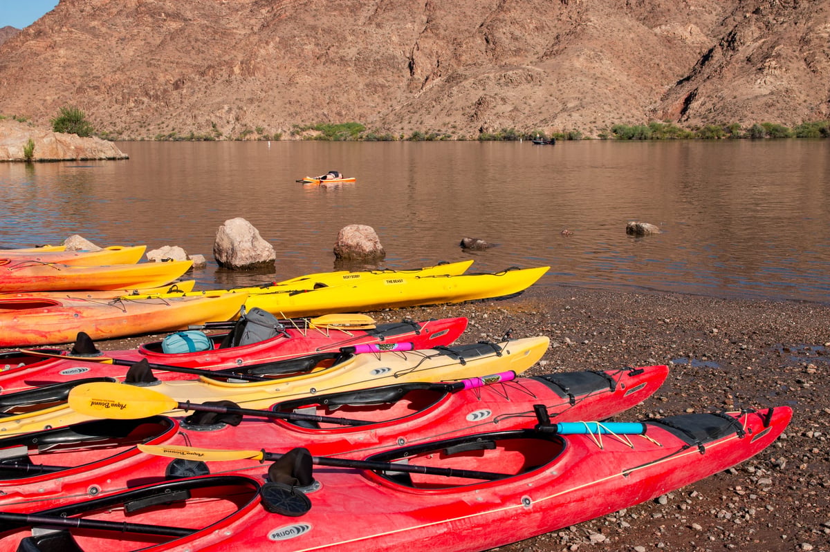 Colorful kayaks resting on the sandy shores of a Jamaican lake