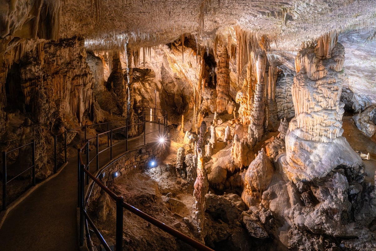 Dramatic limestone cave formations lit inside a cavern