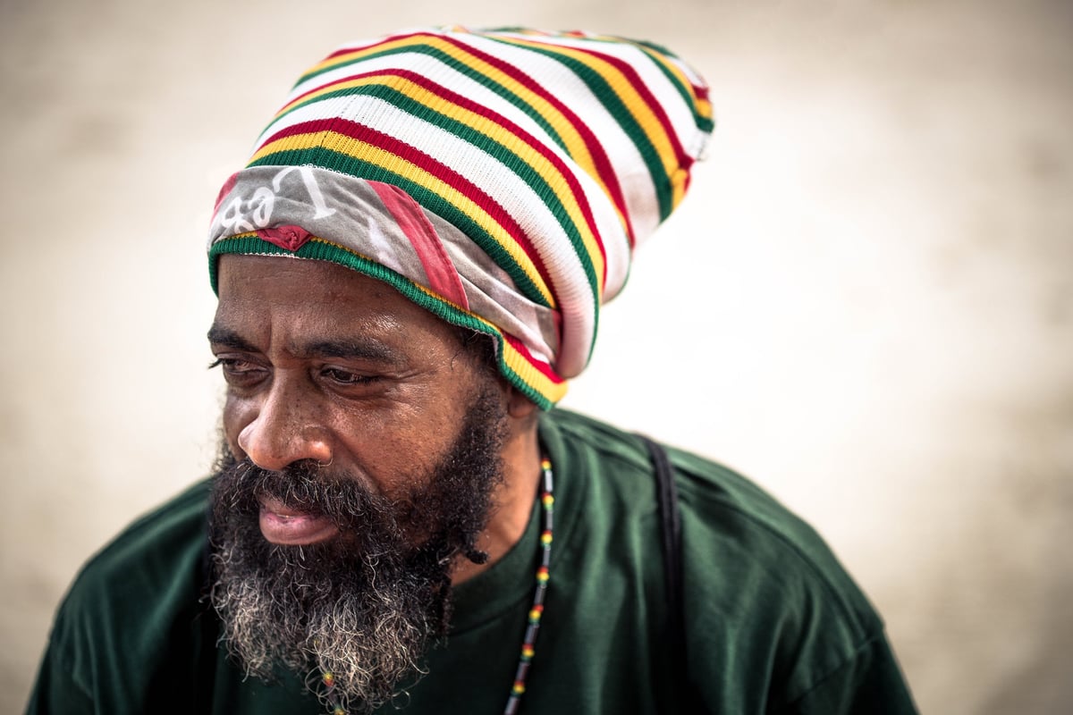A Rastafarian smiling on a tropical beach in Jamaica